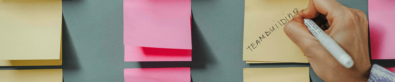 Stacks of post-its with "Teambuilding" written on one